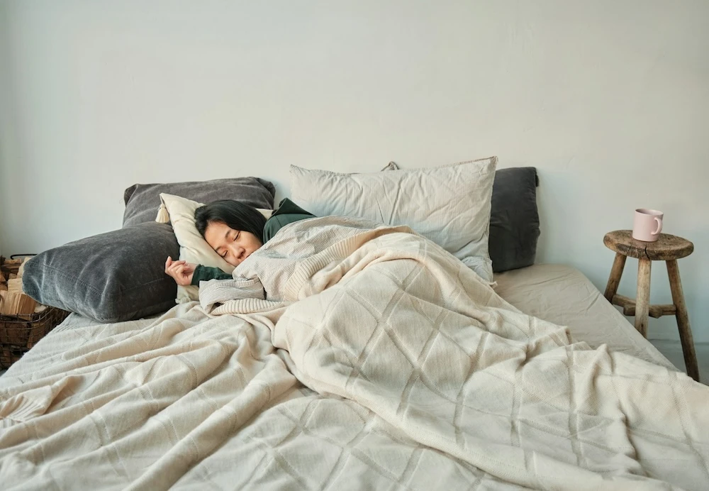 woman wrapped up in bed fast asleep dreaming