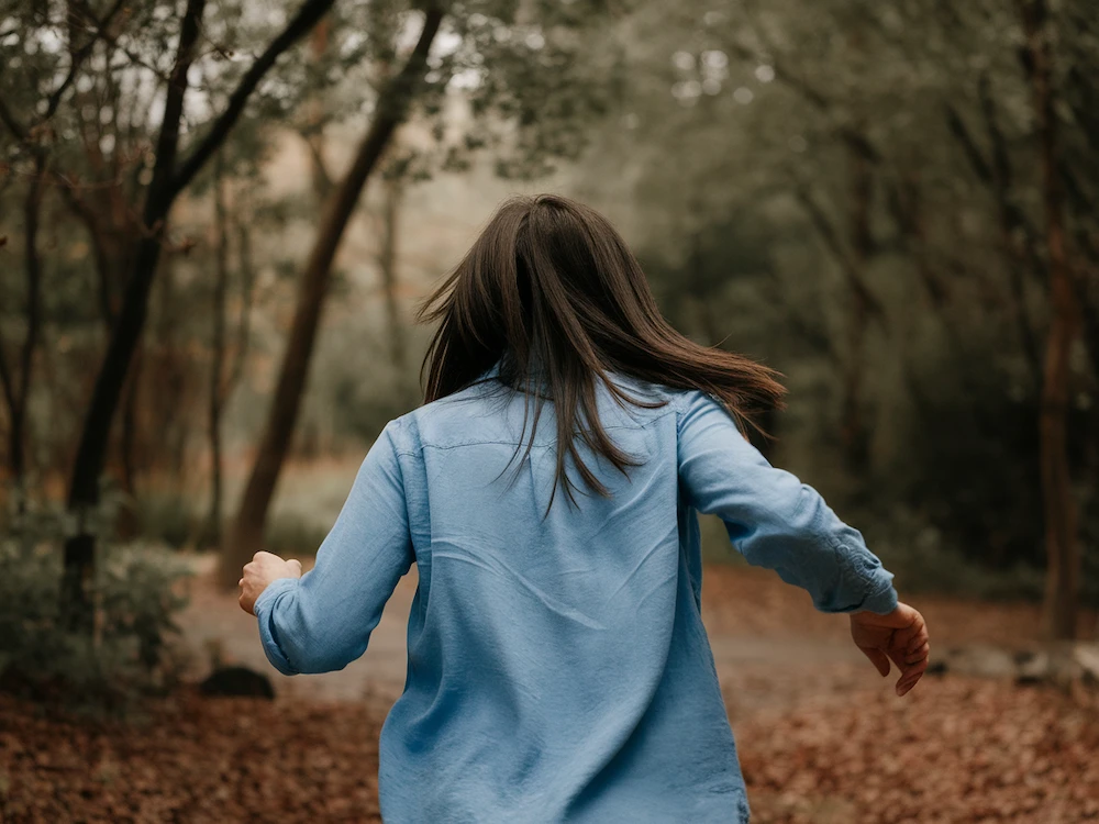 woman being chased through the woods by a white snake in her dreams