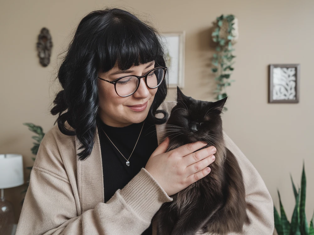 woman holding and petting black cat dream