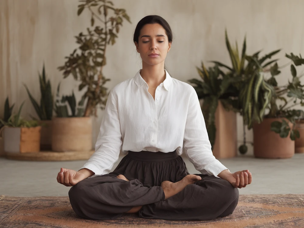 woman sitting on the floor meditating after a snake dream